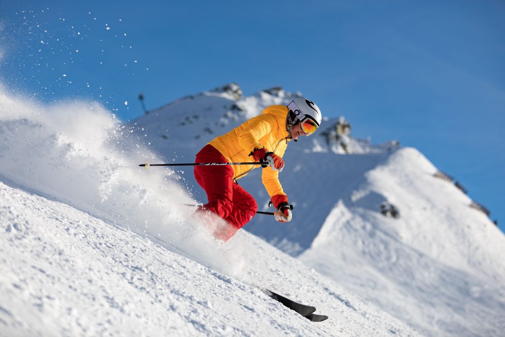 Sciatore in discesa sulla neve grazie alla preparazione presciistica